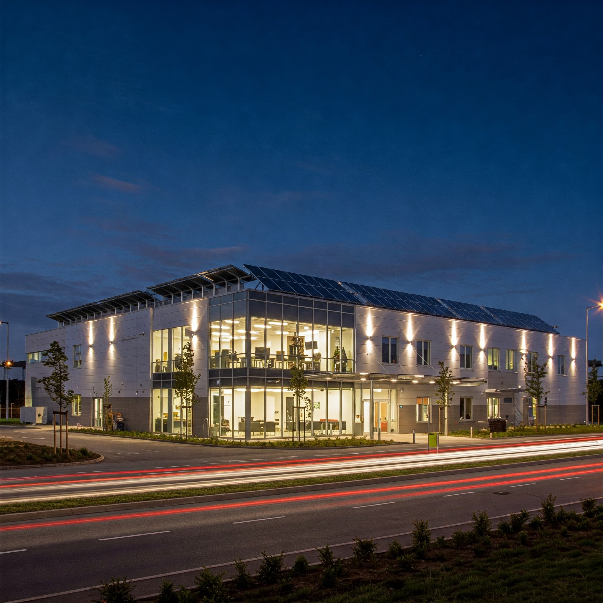 Commercial building with solar panels lit at night